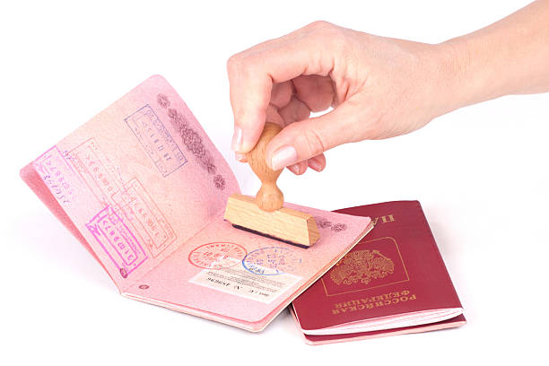 Female hand stamping a passport of Russia over white 40483