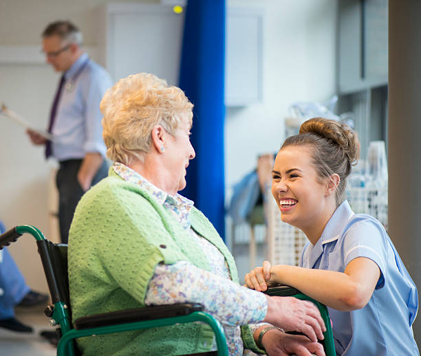 senior woman laughing with nurse on the ward or nursing home New opportunities press
